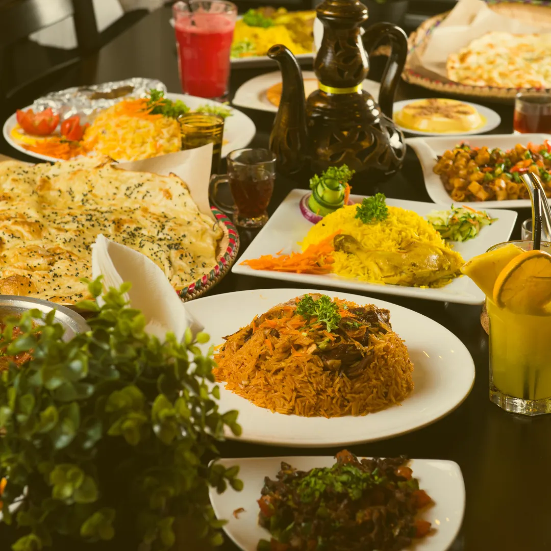 Gedeckter Tisch mit verschiedenen mediterranen Speisen, Reisgerichten, Dips, Fladenbrot und Teekannen
